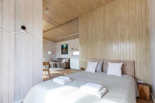 ein Schlafzimmer mit einem großen Bett mit weißen Kissen in der Unterkunft Pineplace twins NIDA in Žaugėdai