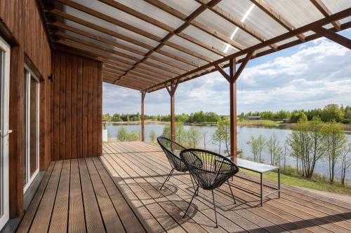 a covered deck with a bench and a table at Pineplace twins NIDA in Žaugėdai