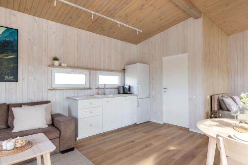 a kitchen and living room with a couch and a table at Pineplace twins NIDA in Žaugėdai