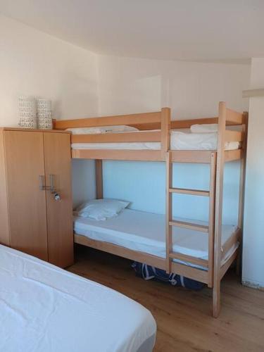 une chambre avec deux lits superposés et un lit dans l'établissement Magnifique t2 duplex vue port, au Cap d'Agde