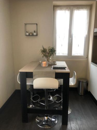 une table de salle à manger avec une chaise blanche dessus dans l'établissement Appartement au pays du Mont-Blanc, à Sallanches