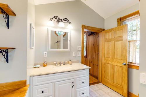 baño con lavabo y puerta de madera en North Pond Home, en Warren