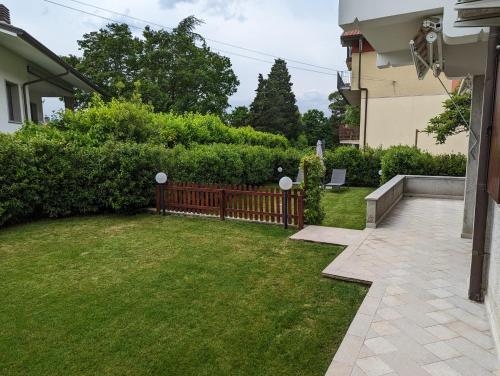 a backyard with a wooden fence and grass at Villa Jasna in Duino