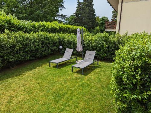 two chairs and an umbrella in a yard at Villa Jasna in Duino