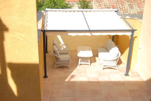 a gazebo with three chairs and a table and chairs at La Centralita de la Abuela in Segovia
