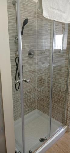 a shower with a glass door in a bathroom at Casa Vacanze Ale e Gio in Piombino