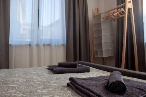 a bedroom with a bed with two towels and a mirror at Green Villa in Saparewo