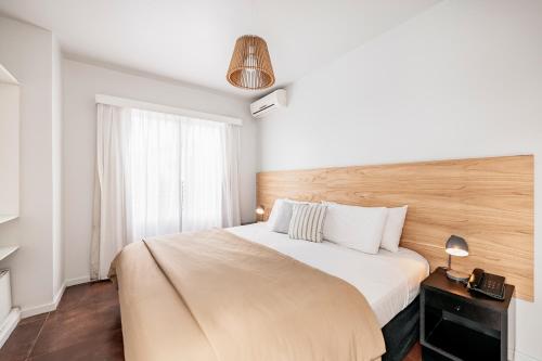 a bedroom with a large white bed and a window at 5411 Soho Hotel in Buenos Aires