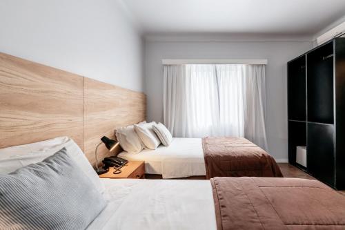 a hotel room with two beds and a window at 5411 Soho Hotel in Buenos Aires