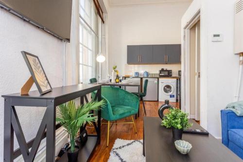 a living room with a table and a kitchen at Newcastle's Most Central Apartment - Sleeps 10 in Newcastle upon Tyne