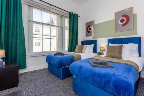 - une chambre avec 2 lits bleus et une fenêtre dans l'établissement Triplex Apartment in Central Newcastle - Sleeps 10, à Newcastle upon Tyne