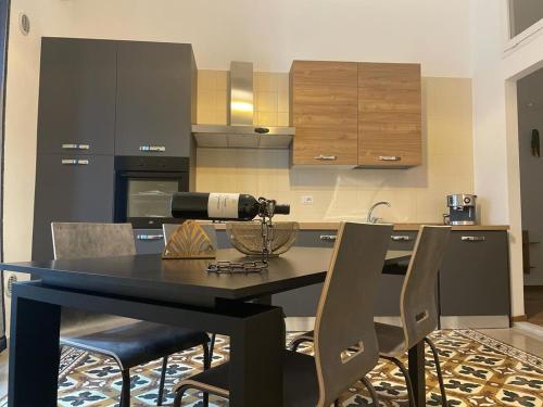 una cucina con tavolo nero e sedie di Maioliche Apartments a Margherita di Savoia