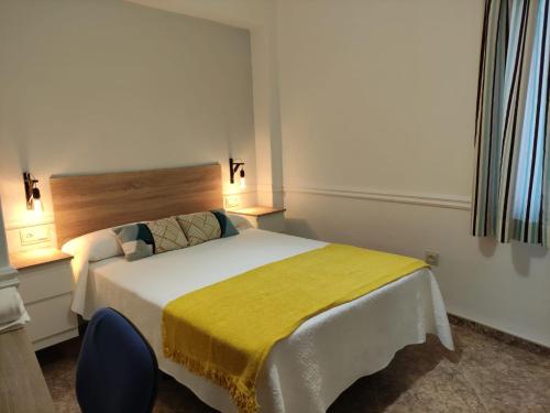 Un dormitorio con una cama con una manta amarilla. en LA DESCALZA en Lucena