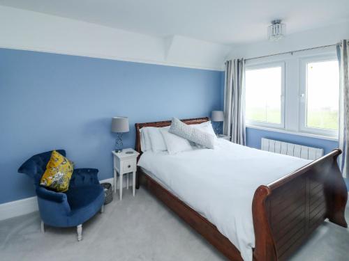 Un dormitorio con una cama grande y una pared azul. en Russell House, en Paignton
