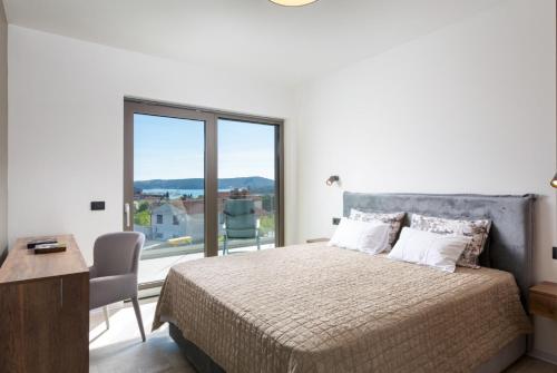 ein Schlafzimmer mit einem Bett und einem großen Fenster in der Unterkunft Villa Suenos Medulin in Medulin