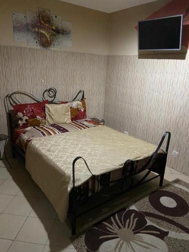 a bed in a room with a tv on the wall at Rincon d'Alicia 1 in Dakar