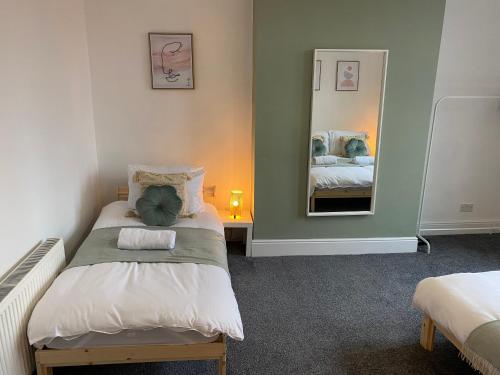 a small bedroom with a bed and a mirror at Overhill 3 bedroom flat 5 beds, free parking, ideal for Contractors in Gateshead