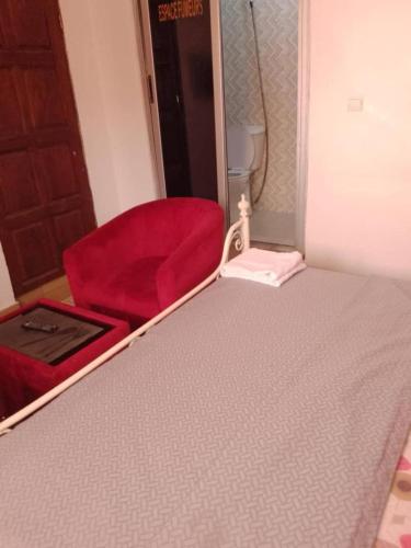 a bedroom with a red bed and a red chair at Rincon d'Alicia 1 in Dakar