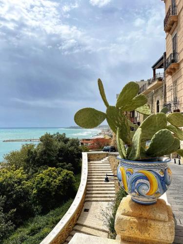 a vase with a plant in it sitting on a sidewalk at Giulietta Normanna in Sciacca