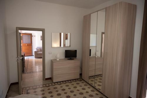 a living room with a door open to a room with a television at Giulietta Normanna in Sciacca