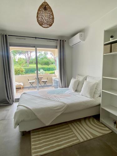 une chambre avec un grand lit et un balcon dans l'établissement Le Maya - studio avec piscine Antibes, à Antibes