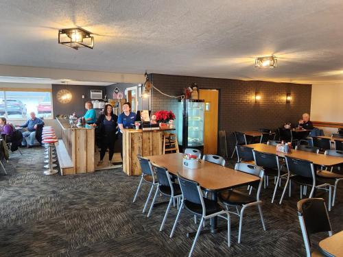 a restaurant with tables and people sitting at a counter at Oak Mar Motel in Oakland
