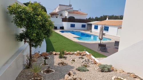 un jardín en miniatura junto a una casa con piscina en Hospedaria do Almargem en Quarteira