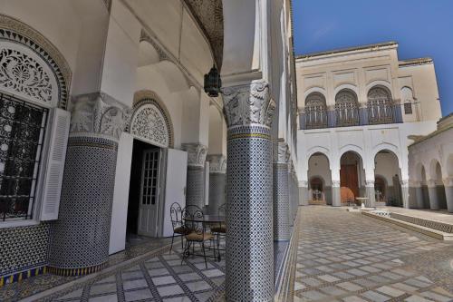 a courtyard of a building with columns and a gate at Studio avec piscine et parking prive in Fez