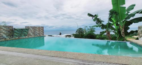 - une piscine avec l'océan en arrière-plan dans l'établissement Seaview Mansion Dalaguete Deluxe Apartment 6, à Dalaguete