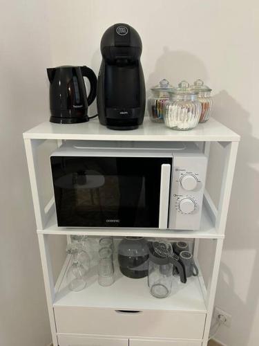 une étagère blanche avec un four micro-ondes. dans l'établissement Le Cocon des Carmes - Hypercentre, à Avignon