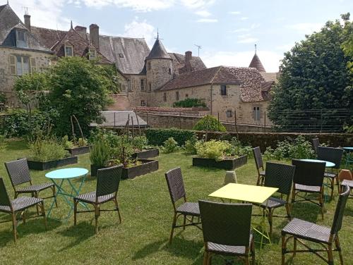 un grupo de mesas y sillas en un patio en les chambres fleuries, en Saint-Benoît-du-Sault