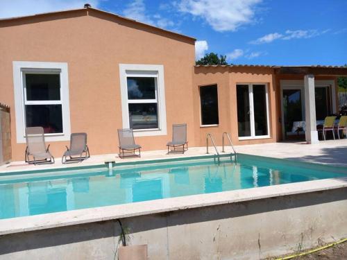 une piscine avec des chaises et une maison dans l'établissement Villa, proche plages, 4 chambres avec piscine privée., à Roquebrune-sur Argens
