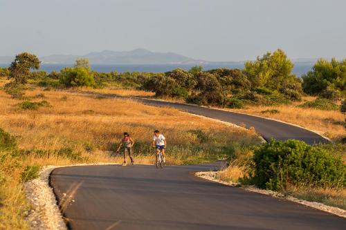 two people riding bikes down a road at Premium Residence Virotel in Vir