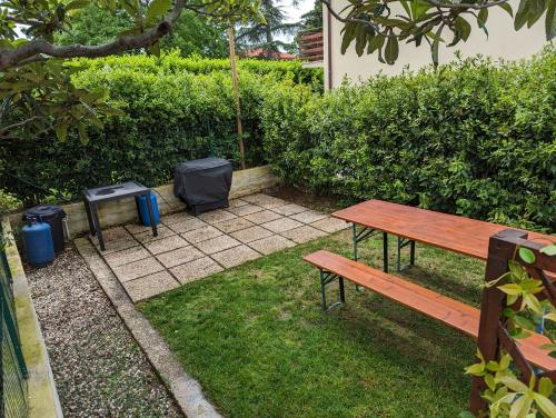 a picnic table and two trash cans in a yard at Villa Jasna in Duino