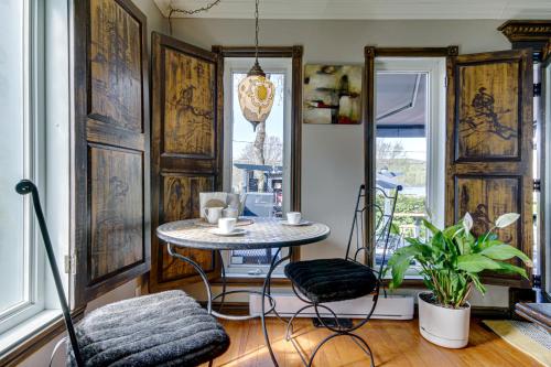 a room with a table and two chairs and a window at Le petit Manoir Spa et Vue sur rivière St Maurice in Grandes-Piles