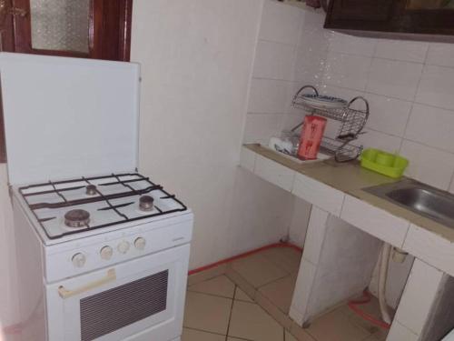 a small kitchen with a stove and a sink at Rincon d'Alicia in Dakar