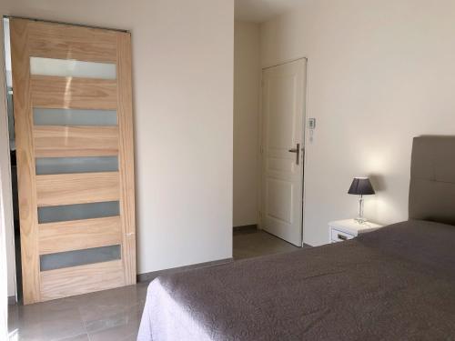 a bedroom with a bed and a wooden door at Appartement 140M2 villa cargèse in Cargèse