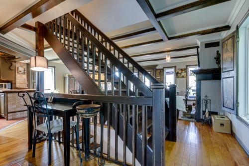 a staircase in a living room with a table and a dining room at Le petit Manoir Spa et Vue sur rivière St Maurice in Grandes-Piles