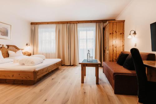 a hotel room with a bed and a couch at Naturhotel Schütterbad in Unken
