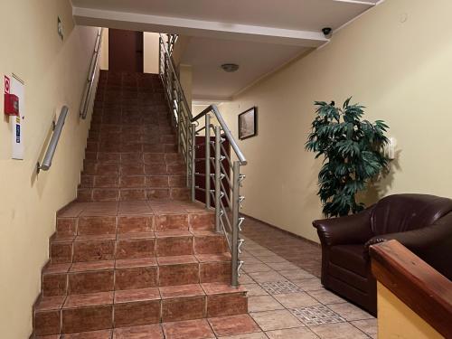 a staircase in a room with a couch and a stair case at Hotel Omega in Ostrów Wielkopolski