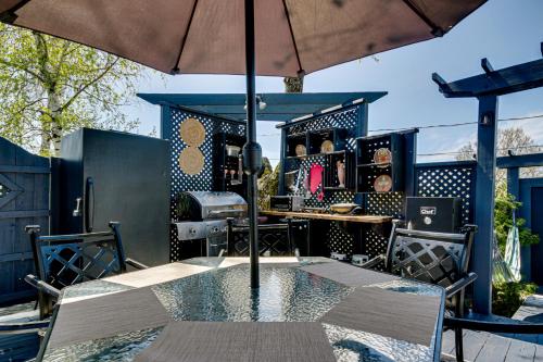 a table with an umbrella on a patio at Le petit Manoir Spa et Vue sur rivière St Maurice in Grandes-Piles