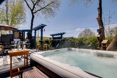 a hot tub in a backyard with a table and chairs at Gite le petit Manoir Vue sur rivière St Maurice in Grandes-Piles