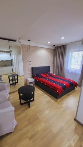 um quarto com uma cama grande e um cobertor vermelho em Garsoniera în centrul orașului vis a vis de hotel radisson em Bucareste