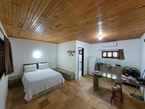 een slaapkamer met een bed en een bureau. bij Chalés Hibiscus Pipa - ar, cozinha e banheiros privados, estacionamento interno in Pipa