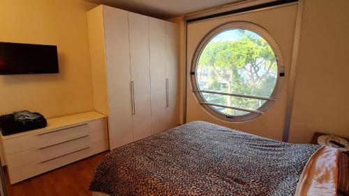 a bedroom with a bed and a round window at Residence La Settima in Milano Marittima