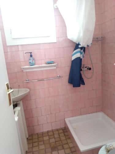 a pink bathroom with a toilet and a sink at Maison avec Jardin privé in Saint-Hilaire-de-Riez