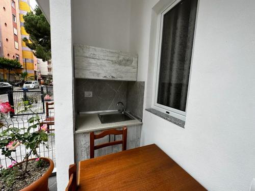 une cuisine avec une table et un évier ainsi qu'une fenêtre. dans l'établissement Oasis The Villa, à Durrës