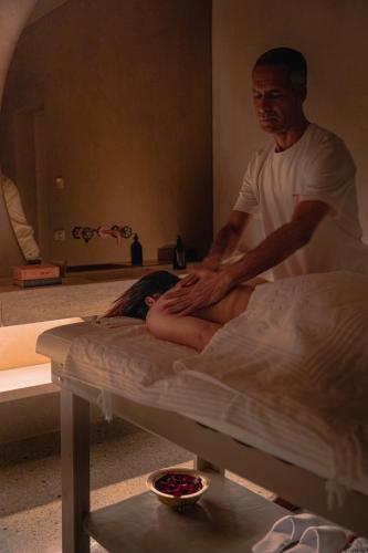 a man sitting on a bed in a room at 72 Hotel & Spa in Marrakech