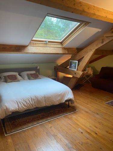um quarto com uma cama e uma janela grande em Séjour -Chambre d'hôte em Saint-Ours
