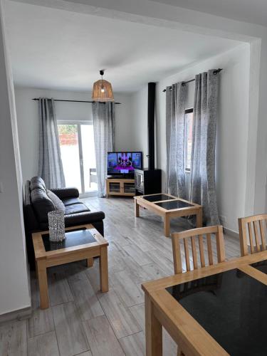 a living room with a couch and a tv at Casa Maria João in Lagos